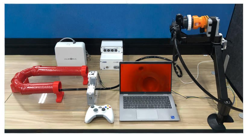 Colonoscopy robot test setup with the robotic actuation system, phantom colon, NDI Aurora field generator, and tip camera.